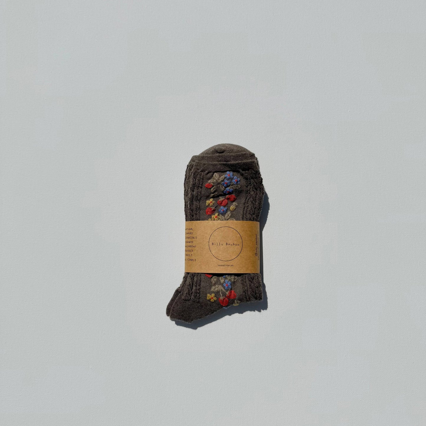 Pair of brown socks with a label on a light gray background
