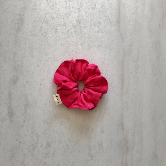 Pink scrunchie on a textured gray background