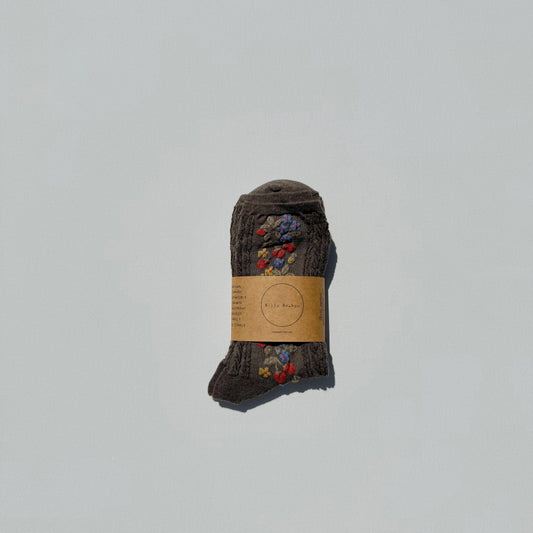 Pair of brown socks with a label on a light gray background