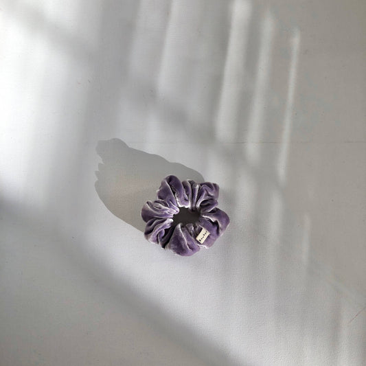 Purple flower-shaped object on a white surface with shadows